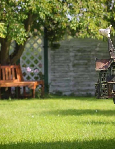 Dekoratives Vogelhaus im Garten des großen Wassergrundstücks
